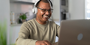 Man watching a video on a computer with a headset