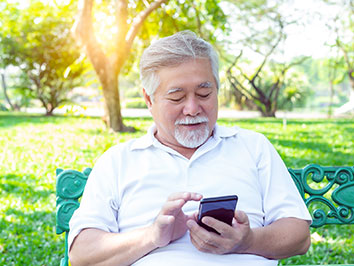 Man looking at phone in a park.